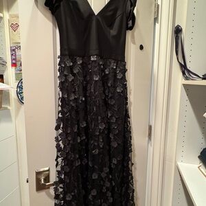 Floral appliqués at the skirt elevate the elegant feel V-neck gown XSCAPE.